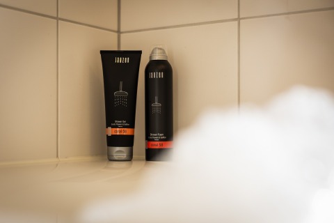 Dos productos de ducha en un estante dentro de la ducha en Wellness Lodge XL, Hof van Salland, Países Bajos.