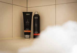 Dos productos de ducha en un estante dentro de la ducha en Wellness Lodge XL, Hof van Salland, Países Bajos.