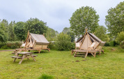Two Bivouac safari tents at Campsite Seasonova Lac de Bournazel, France, set among grass and trees.