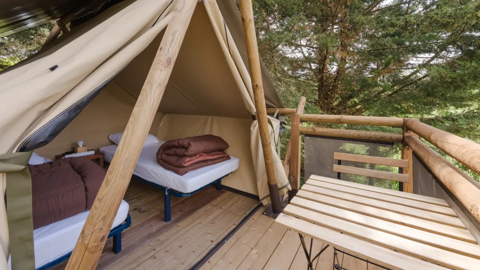 Interieur van een Bivouac-tent met twee bedden en terras op Campsite Seasonova Lac de Bournazel in Frankrijk.