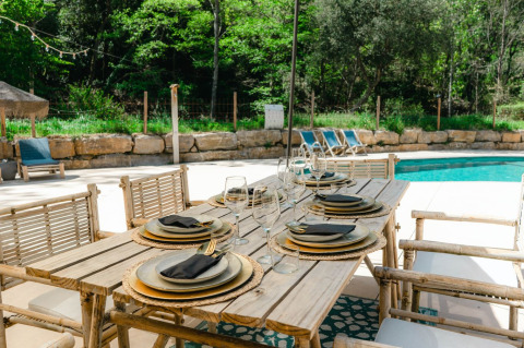 Buiteneettafel aan zwembad bij Can Bora Lodges vakantiepark in Catalonië, Spanje, sfeervol gedekt.