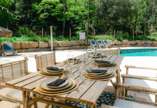 Buiteneettafel aan zwembad bij Can Bora Lodges vakantiepark in Catalonië, Spanje, sfeervol gedekt.