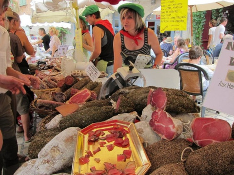Marktkraam bij Domaine Les 2 Soleils in de Provence met lokale vleeswaren en drukte bij de verkoper.