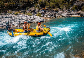 Vier mensen peddelen in een gele raft over een wilde rivier bij Serres in de Provence-Alpes-Côte d’Azur, Frankrijk.
