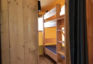 Interieur van de safaritent Lodgetent met badkamer op Camping Luna del Monte in Italië met houten stapelbed.