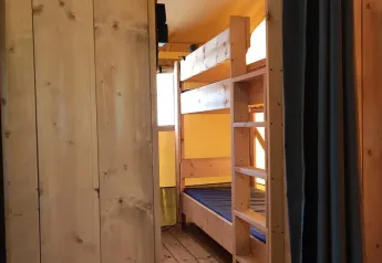 Interieur van de safaritent Lodgetent met badkamer op Camping Luna del Monte in Italië met houten stapelbed.