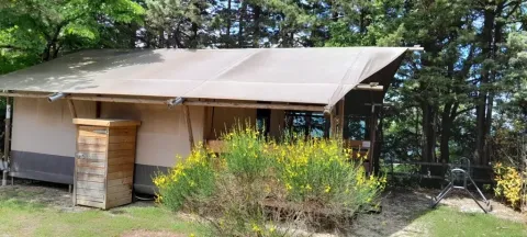 Safaritent Lodgetent met badkamer op Camping Luna del Monte in Italië, tussen bomen en natuur.