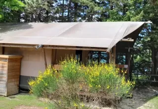 Safaritent Lodgetent met badkamer op Camping Luna del Monte in Italië, tussen bomen en natuur.