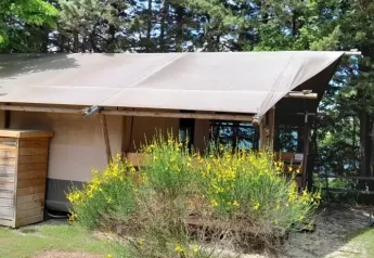 Safaritent Lodgetent met badkamer op Camping Luna del Monte in Italië, tussen bomen en natuur.