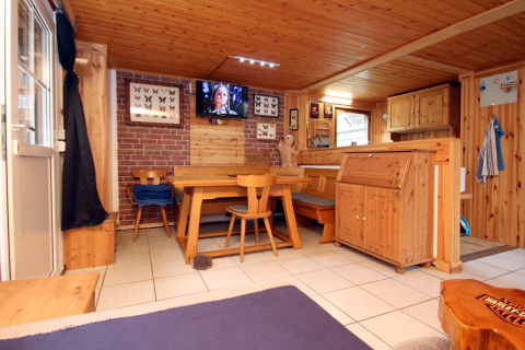 Cozy lodge interior at Holiday home Susanne 58 qm in Germany with wood furnishings and dining area.
