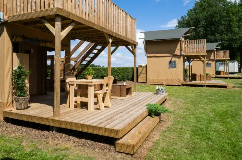 Buitenbeeld van Glampingtent 2p met houten terras en zitplaats op Camping Mareveld in Nederland.