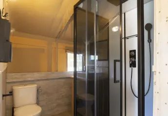 Modern bathroom with shower and toilet inside a Glampingtent at Campsite Mareveld in the Netherlands.