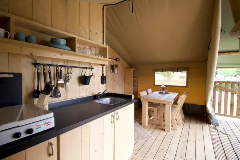 Knusse keuken en eethoek in Glampingtent 4p op Camping Mareveld in Nederland, met houten interieur.