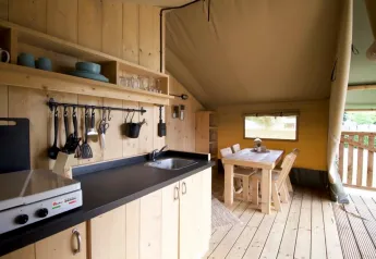 Knusse keuken en eethoek in Glampingtent 4p op Camping Mareveld in Nederland, met houten interieur.