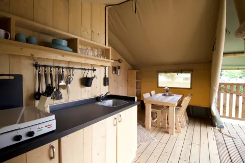 Cucina e zona pranzo accoglienti nella tenda Glampingtent 4p al Campeggio Mareveld nei Paesi Bassi.