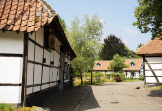 Village scene at Campsite Mareveld in Limburg, Netherlands, featuring half-timbered houses and lush greenery.