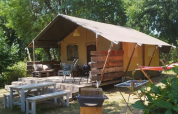 Tenda safari al Camping Moulin de Chaules in Francia con veranda, sedute esterne e barbecue nel verde.