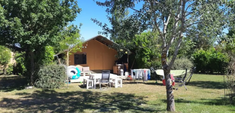 Safari-Zelt auf dem Campingplatz Moulin de Chaules in Frankreich, mit Gartenmöbeln und Wäscheständer draußen.