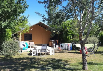 Safari-Zelt auf dem Campingplatz Moulin de Chaules in Frankreich, mit Gartenmöbeln und Wäscheständer draußen.