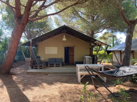 Safari-Zelt auf dem Campingplatz Casa dei Prati in Italien, mit Terrasse, Sitzbereich und Hängematte im Freien.