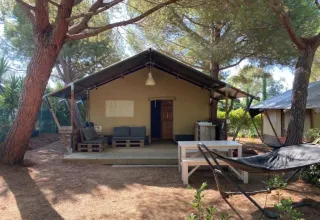 Safari-Zelt auf dem Campingplatz Casa dei Prati in Italien, mit Terrasse, Sitzbereich und Hängematte im Freien.