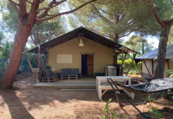 Safari-Zelt auf dem Campingplatz Casa dei Prati in Italien, mit Terrasse, Sitzbereich und Hängematte im Freien.