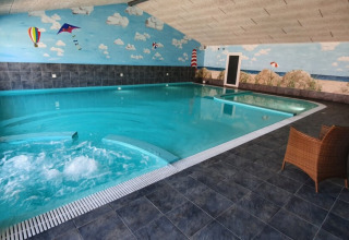 Indoor swimming pool with jacuzzi and beach mural at Tornby Strand Camping, North Jutland, Denmark.
