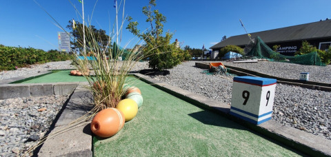 Mini-golf course at Tornby Strand Camping in North Jutland, Denmark, with decorations and blue sky.