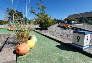 Minigolfbaan op Tornby Strand Camping in Noord-Jutland, Denemarken, met decoratie en zonneschijn.