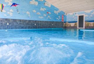 Piscina coperta con murale colorato di cielo e spiaggia presso Tornby Strand Camping nel Jutland settentrionale, Danimarca.