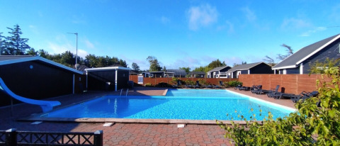 Piscina al aire libre con tobogán en Tornby Strand Camping, parque vacacional en Jutlandia del Norte, Dinamarca.