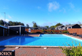 Piscina al aire libre con tobogán en Tornby Strand Camping, parque vacacional en Jutlandia del Norte, Dinamarca.