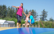 Woman and two children play on a large inflatable jumper at Tornby Strand Camping in North Jutland, Denmark.