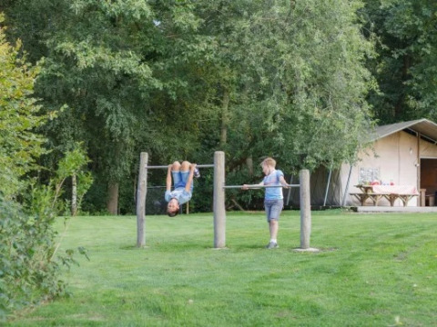 Zwei Kinder spielen an Turnstangen im Landrijk de Reesprong Ferienpark in Overijssel, Niederlande.