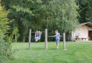 Zwei Kinder spielen an Turnstangen im Landrijk de Reesprong Ferienpark in Overijssel, Niederlande.