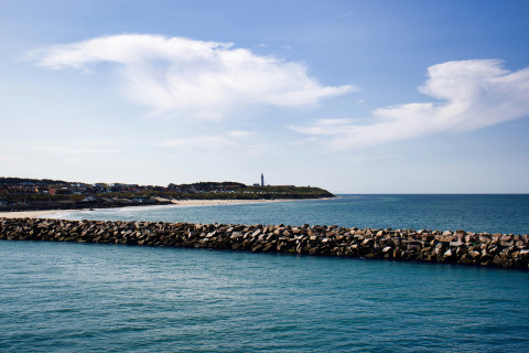 Vista desde Tornby Strand Camping en Jutlandia del Norte, Dinamarca, con muelle de rocas y línea costera.