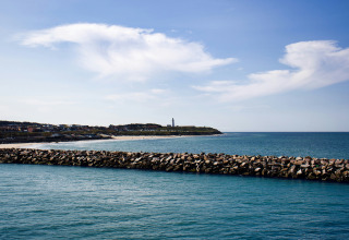Vista desde Tornby Strand Camping en Jutlandia del Norte, Dinamarca, con muelle de rocas y línea costera.
