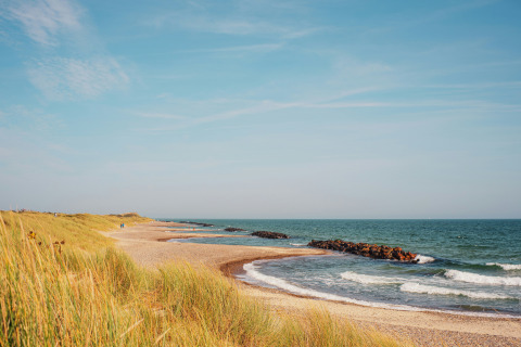 Paesaggio costiero a Tornby Strand Camping, Jutland settentrionale, Danimarca, con spiaggia sabbiosa e onde leggere.
