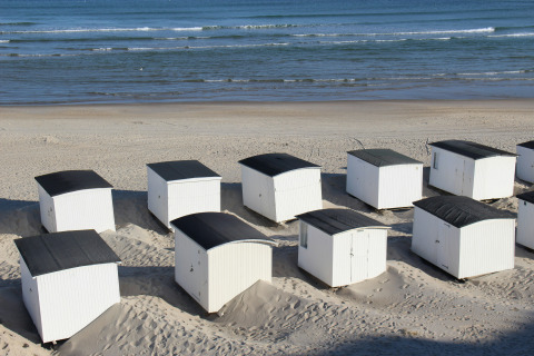 Casetas de playa blancas con techos negros en Tornby Strand Camping, Jutlandia del Norte, Dinamarca.