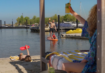 Vacanza in spiaggia all'Oesterdam Resort, Paesi Bassi, relax familiare, paddleboard e giochi sulla sabbia.