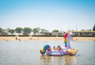 Kinderen spelen op een grote opblaasbare eenhoorn op het meer bij Arden Parks Tulderheyde, Antwerpen