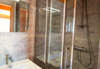 Moderne badkamer in een chalet op Camping Mareveld in Nederland, met douchecabine en wastafel met spiegel.