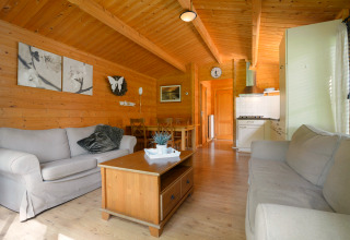 Wooden interior of a Chalet at Campsite Mareveld in the Netherlands with sofas and a small kitchen.
