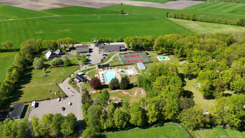 Luchtfoto van vakantiepark Park Drentheland in Drenthe, Nederland, met zwembaden, tennisbanen en bomen.