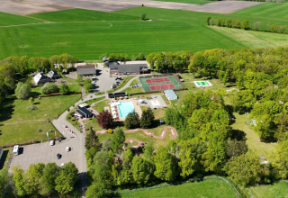 Luchtfoto van vakantiepark Park Drentheland in Drenthe, Nederland, met zwembaden, tennisbanen en bomen.