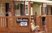 Famille détendue sur la terrasse de la SunLodge Maple au Altomincio Family Park en Italie.