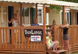 Gezin relaxt op het terras van SunLodge Maple in het Altomincio Family Park in Italië.