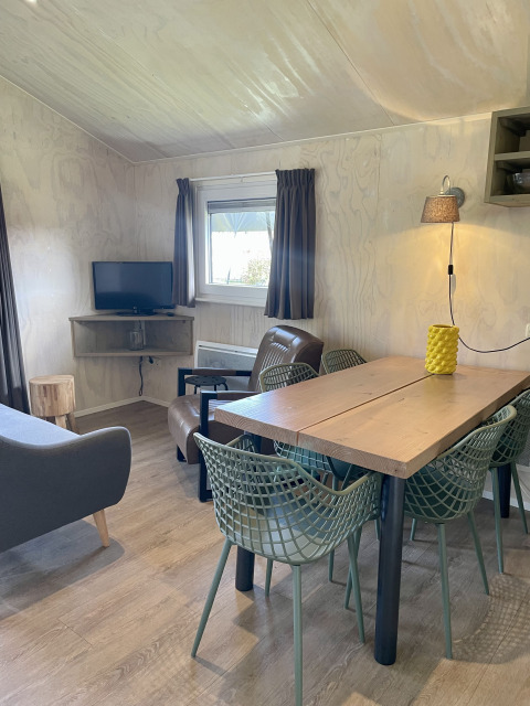 Interior of a safari lodge tent at Campsite de Noetselerberg, Netherlands, featuring a wooden dining table.