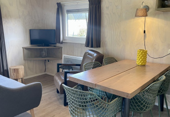 Interior of a safari lodge tent at Campsite de Noetselerberg, Netherlands, featuring a wooden dining table.