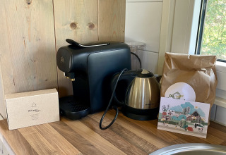 Coffee machine, electric kettle, and bag of coffee on wooden counter in safari lodge at Campsite de Noetselerberg.